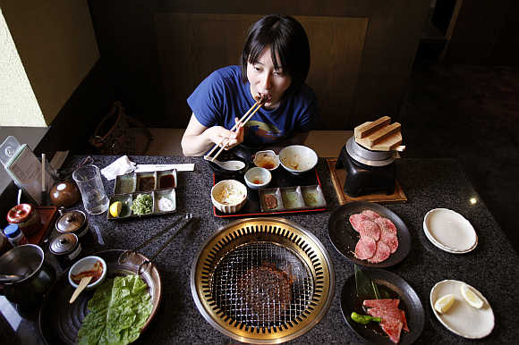 Rina Mitsutake eats a piece of beef strip in Yokohama, south of Tokyo, Japan.