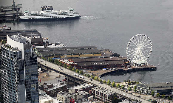 A view shows the Seattle Great Wheel (bottom) and a Washington State ferry boat on the Elliott Bay waterfront in Seattle, Washington.