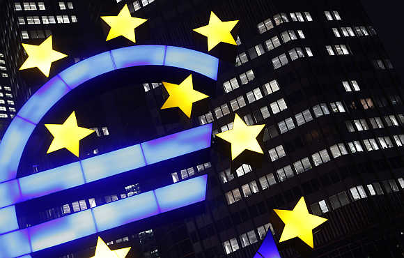 An illuminated euro sign in front of the European Central Bank headquarters in Frankfurt, Germany.