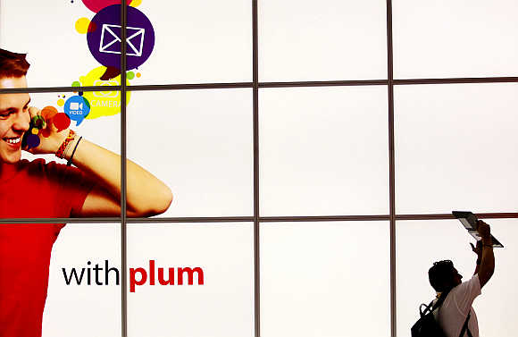 A man uses an iPad to take a video of the Plum Mobile exhibit in New Orleans, Louisiana, United States.
