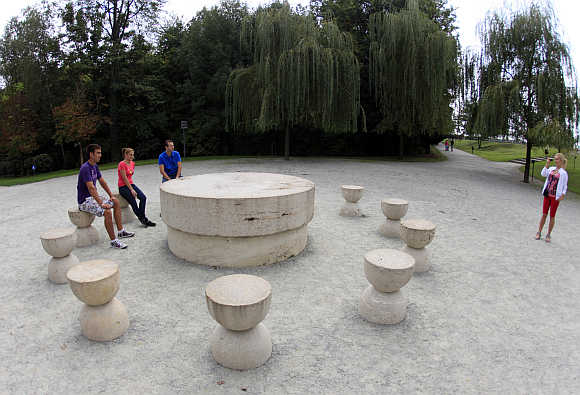 Tourists sit around the Table of Silence, a limestone sculpture, in Targu Jiu, 300km west of Bucharest.