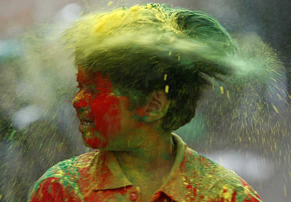 A boy shakes his head to remove coloured powder after it was applied on him while celebrating Holi in Agartala, Tripura.