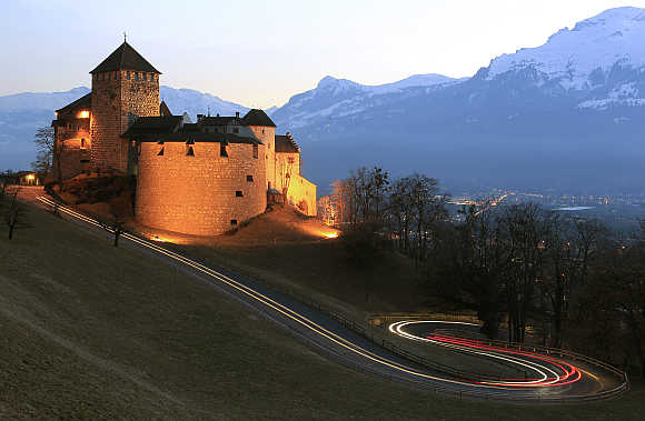 Cars drive past Vaduz Castle in capital Vaduz, Liechtenstein.