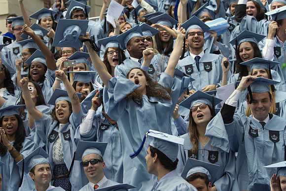 Graduates from Columbia University's School of Journalism cheer during the commencement ceremony in New York.