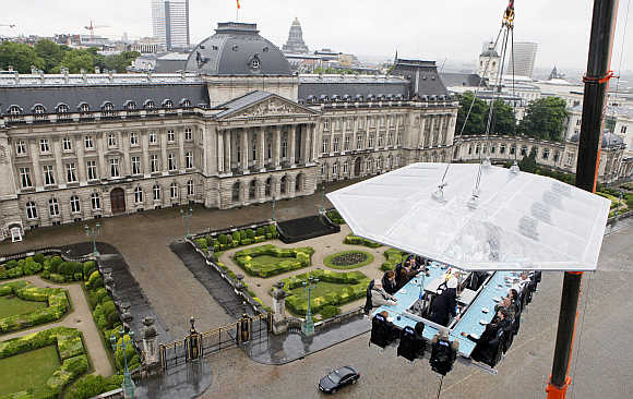 Guests enjoy a 'Dinner in the Sky' on a platform hanging in front of the Royal Palace in Brussels, Belgium.