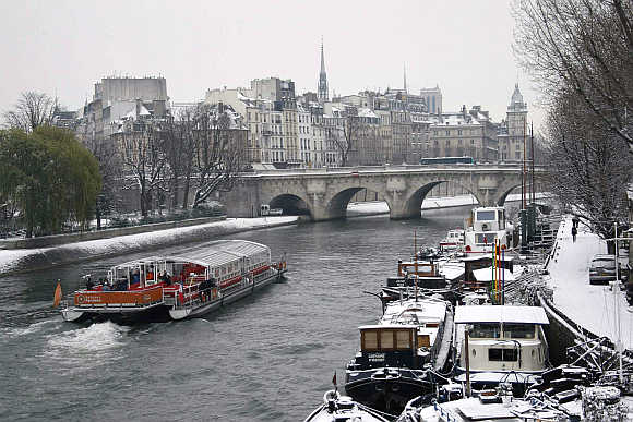 A 'bateaux mouches' tourist boat makes its way up the River Seine in Paris, France.
