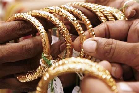 A woman holds gold bangles at a jewellery shop in Kolkata.