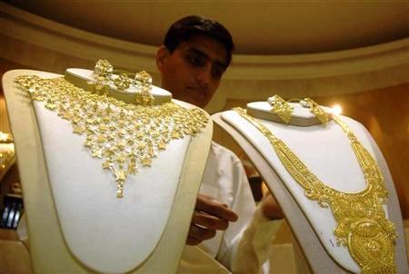 A salesman arranges gold necklaces at a jewellery shop in Agartala.