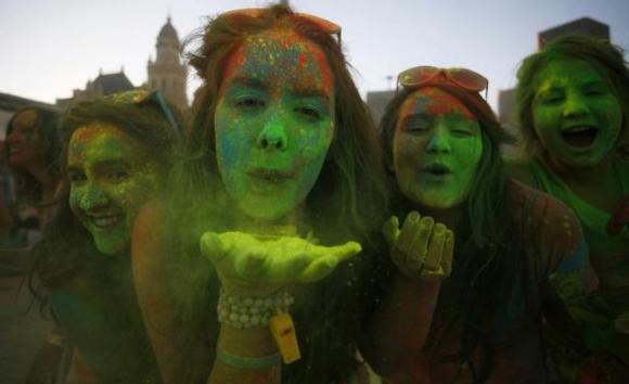 Revellers blow coloured cornflour powder as they take part in the Holi festival.