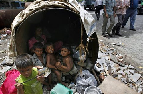 Children eat in their his make-shift home in an unused waterpipe at a street in Mumbai.