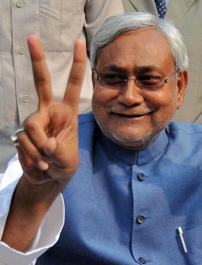 Bihar Chief Minister Nitish Kumar flashes a V-sign during a news conference