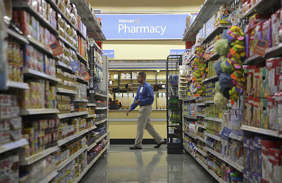 A worker walks past a pharmacy in Walmart Express store in Chicago.