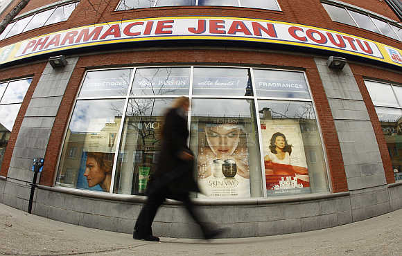 A pedestrian walks past a Jean Coutu pharmacy in downtown Montreal, Canada.