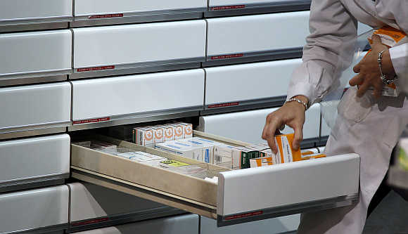 A chemist places medicines in a drawer at a pharmacy in Madrid, Spain.