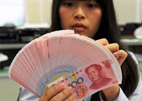An employee counts Chinese yuan notes inside a bank in Taipei.