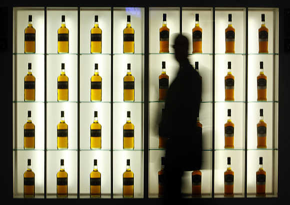 A visitor walks past an alcohol stand during the Tax Free World Association exhibition in Cannes, southeastern France.