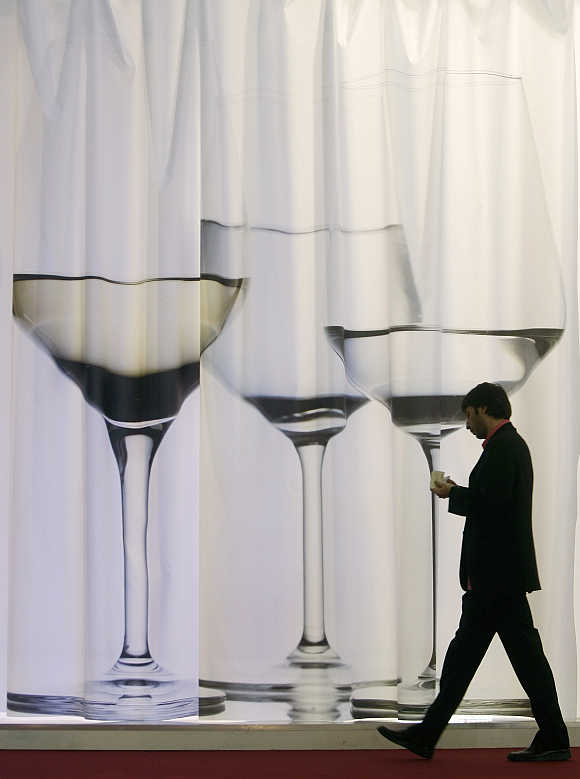 A visitor walks past a wine display at Alimentaria trade show in Barcelona, Spain.