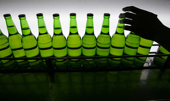 A man picks up a bottle at an assembly line inside the Taiwan Beer factory in Jhunan, Miaoli County.