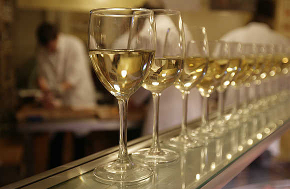 Glasses of white wine are lined up for students to drink at the end of their evening butchery class at the Ginger Pig butchery shop in central London.