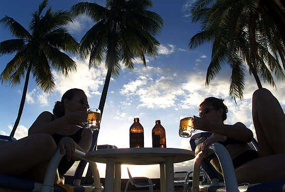 Tourists drink local beer at a beach-side hotel in Suva, Fiji.