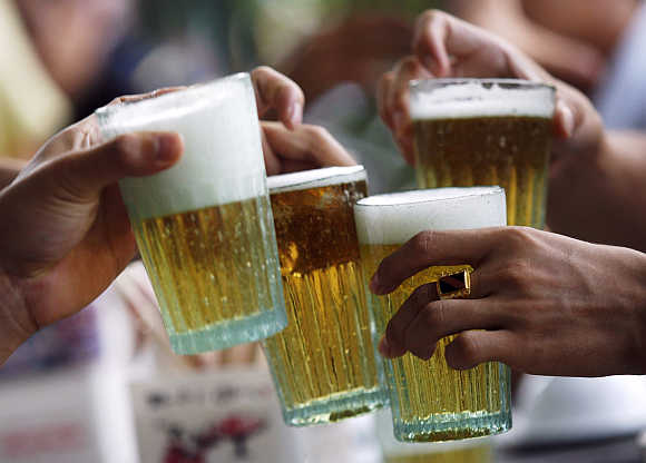 Men drink beer at a restaurant in Hanoi, Vietnam.
