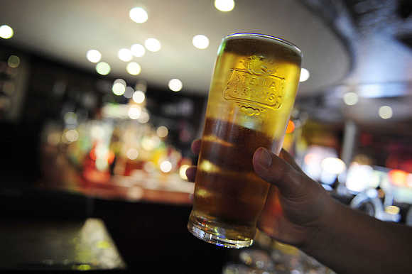 A customer poses for the camera with a pint of beer in a public house in Leeds, northern England.