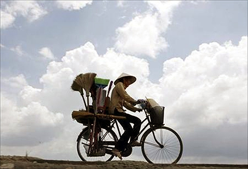 A vendor rides a bicycle on a highway outside Hanoi.