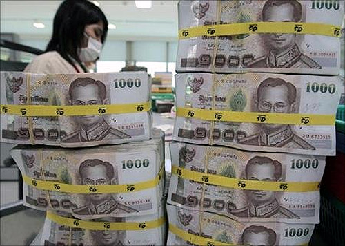 A bank employee counts Thai baht notes at Kasikornbank in Bangkok.