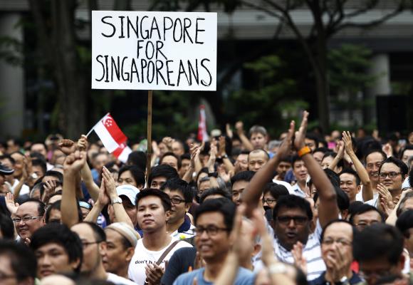Protesters react during a May Day protest against high living costs and immigration policies at Hong Lim Park in Singapore.