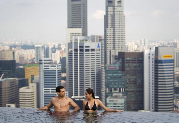 A couple in the infinity pool of the Skypark that tops the Marina Bay Sands hotel towers in Singapore.