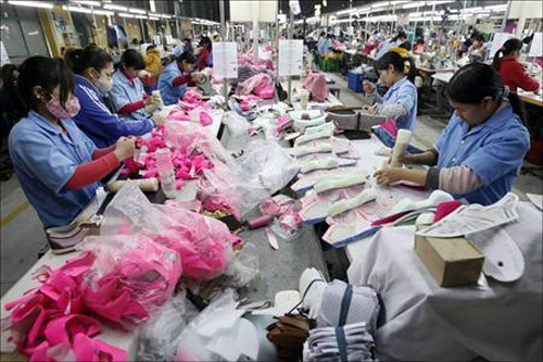 Employees work on an assembly line at a shoe factory in Tan Lap village, outside Hanoi.