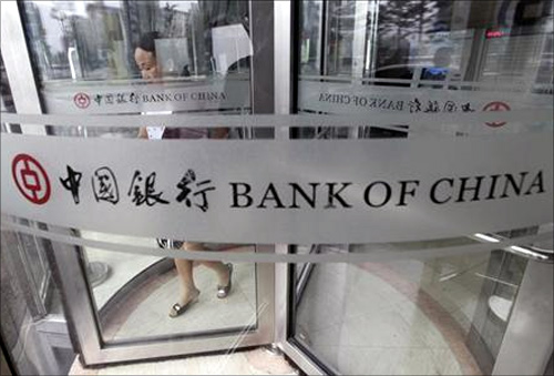 A woman leaves a branch of Bank of China in Beijing.