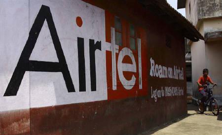 A boy rides his bicycle past an advertisement of Bharti Airtel in Kochi.
