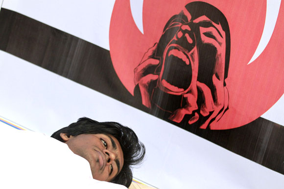 An activist from Magic Movement lies on the ground wearing a traditional Muslim death robe as he takes part in a protest in front of Bangladesh Garment Manufacturers and Exporters Association building in Dhaka.