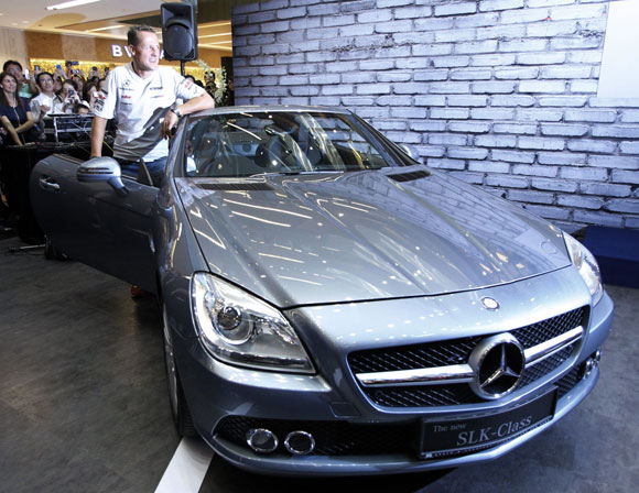 Formula One driver Michael Schumacher of Germany poses next to a Mercedes SLK.