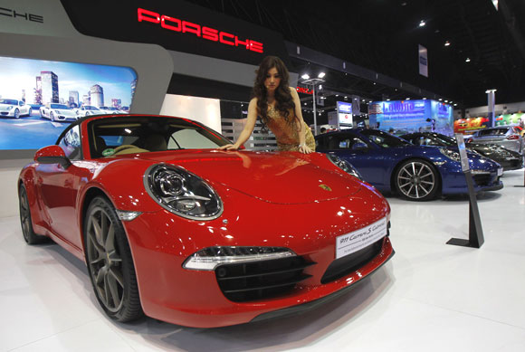 A model poses beside a Porsche 911 Carrera S Cabriolet.