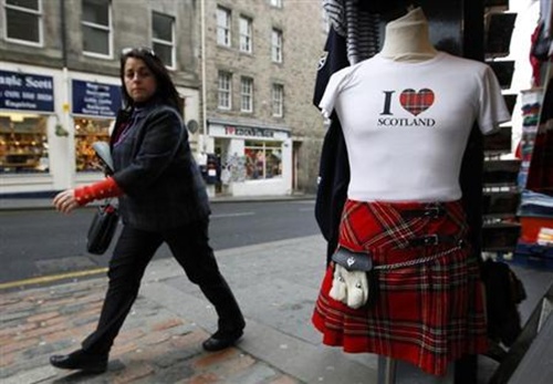 A woman walks past a tourist shop in the Royal Mile in Edinburgh, Scotland.