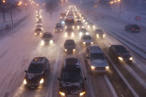 Rush hour traffic crawls as blowing snow batters Lake Shore Drive in Chicago.