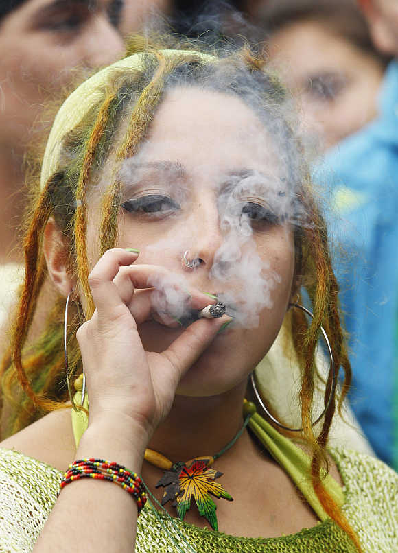 A woman smokes a joint during a rally against drug trafficking and in favour for the legalisation of self-cultivation of marijuana for medicinal and recreational purposes in Valparaiso city, about 121km northwest of Santiago, Chile.