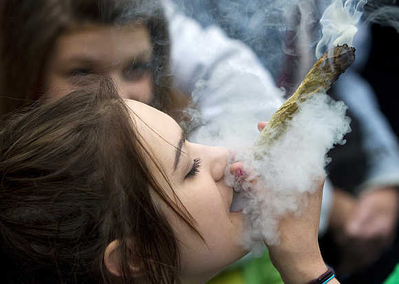 A woman smokes a large marijuana joint at the Vancouver Art Gallery during the annual 4/20 day, which promotes the use of marijuana, in Vancouver, British Columbia, Canada.