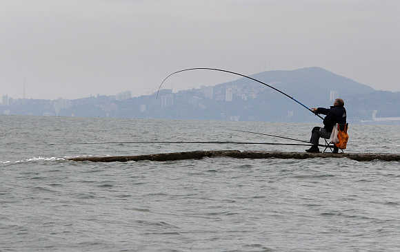 A man fishes in the waters of the Black Sea in Sochi, Russia.