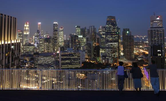 People look at the skyline of the central business district from the Skybridge of The Pinnacles at Duxton public housing estate in Singapore.