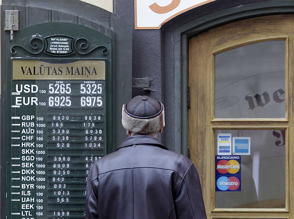 A man looks at currency rates near the exchange office in Riga, Latvia.