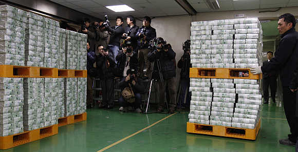 A worker moves stacks of South Korean won for delivery to commercial banks at Bank of Korea's headquarters in Seoul, South Korea.