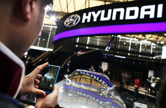 A man takes pictures of a Hyundai car during the 15th Shanghai International Automobile Industry Exhibition in Shanghai.