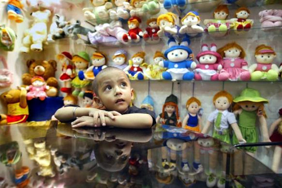 Kunal, a four-year-old Indian boy, looks at dolls at an exhibition in Calcutta.