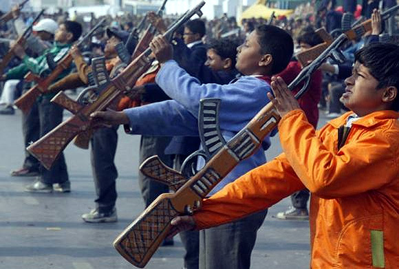School children with toy guns perform during the full dress rehearsal for the Republic Day parade in Lucknow.