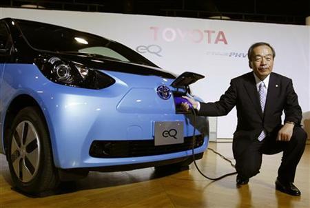 Toyota Motor Corp's Executive Vice President Takeshi Uchiyamada poses next to the company's newly developed compact electric vehicle eQ after a news conference in Tokyo.
