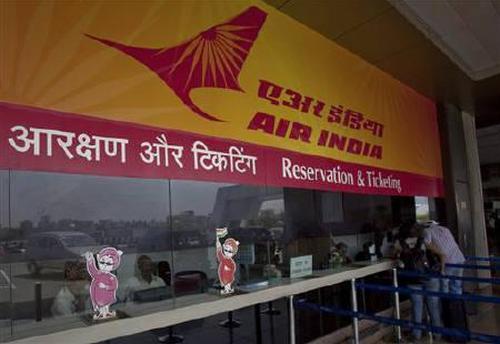 Passengers speak to ticketing staff through the only open counter at the Air India ticket office at the domestic airport in Mumbai.