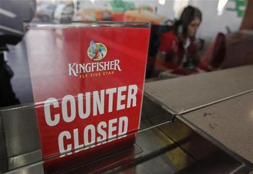 An employee of Kingfisher Airlines works next to a ''counter closed'' sign at their booking office at Mumbai's domestic airport.
